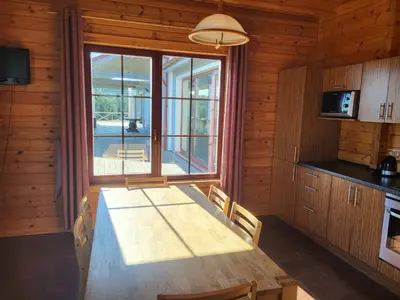 a dining room with a table and a large window at Vytauto kaimas - Didelis namas in Aukštadvaris