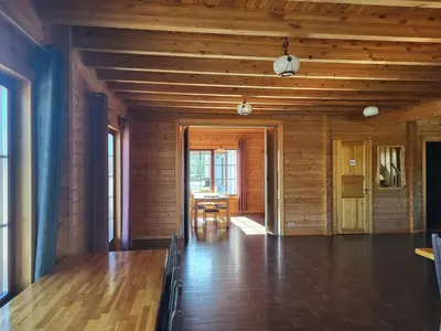 an empty room with a table and wooden walls at Vytauto kaimas - Didelis namas in Aukštadvaris
