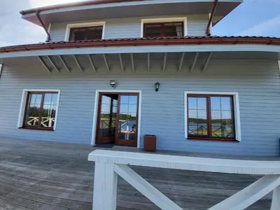 a white house with a bench in front of it at Vytauto kaimas - Didelis namas in Aukštadvaris
