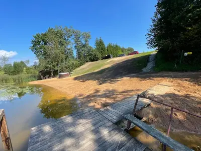 a wooden bridge over a body of water at Mobilus namelis su jacuzi kubilu prie ezero Birvarelax in Kariotiškės