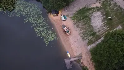a car parked on the shore of a body of water at Mobilus namelis su jacuzi kubilu prie ezero Birvarelax in Kariotiškės