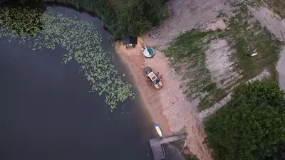a car parked on the shore of a lake at Mobilus namelis su jacuzi kubilu prie ezero Birvarelax in Kariotiškės