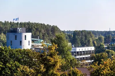 a building with a flag on top of it at DRUSKININKŲ PANORAMA Apartamentai in Druskininkai