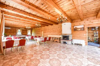 a dining room with tables and chairs and a fireplace at Bražuolėje Pas Juozą- ramiam poilsiui in Trakai