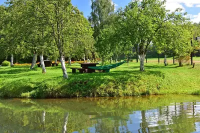 a picnic table in a park next to a river at Bražuolėje Pas Juozą- ramiam poilsiui in Trakai