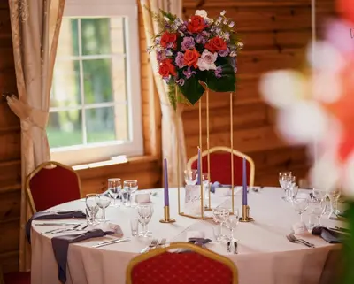 a table with a flower arrangement on top of it at Bražuolėje Pas Juozą- ramiam poilsiui in Trakai