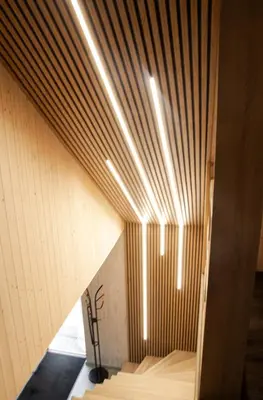 a room with a wooden ceiling with lights at Sodyba Divaiva in Anykščiai