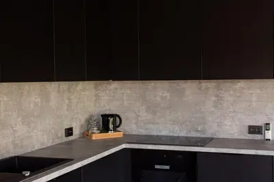 a kitchen with black cabinets and a counter top at Sodyba Divaiva in Anykščiai
