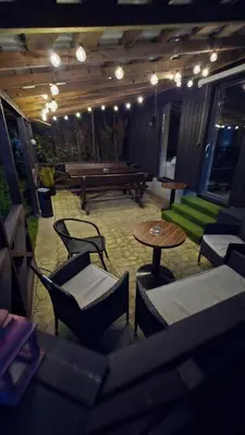 a patio with tables and chairs and a bench at Sodyba Divaiva in Anykščiai