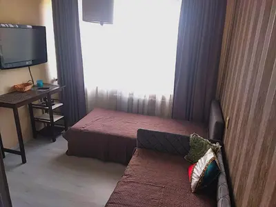 a hotel room with a bed and a couch and a television at Itaja apartment 49 in Šiauliai