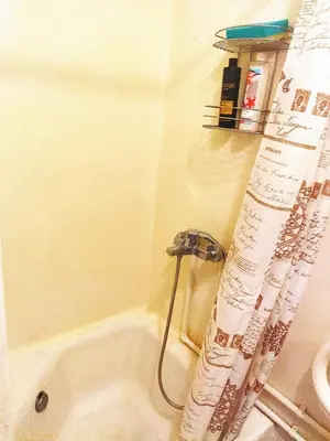 a bathroom with a tub and a shower curtain at Itaja apartment 49 in Šiauliai