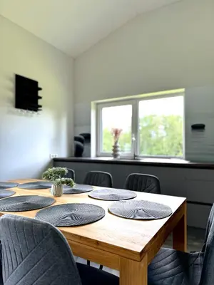 a wooden table with chairs around it in a room at Kaštonų krantas in Antotylʼtse