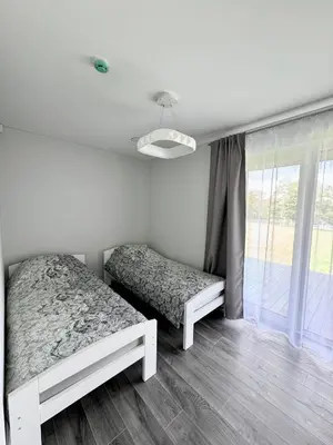 a bedroom with two beds and a window at Kaštonų krantas in Antotylʼtse