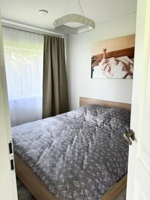 a bedroom with a bed and a window at Kaštonų krantas in Antotylʼtse