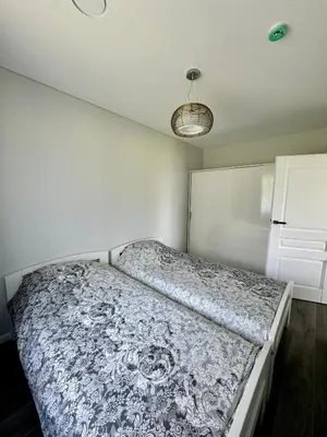 a bedroom with a large bed with a blue and white blanket at Kaštonų krantas in Antotylʼtse