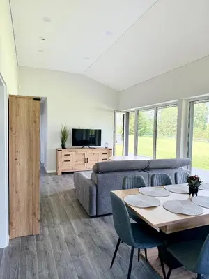 a living room with a couch and a table at Kaštonų krantas in Antotylʼtse