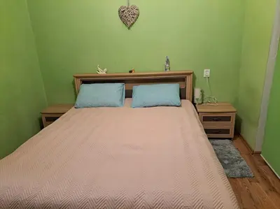 a bedroom with a large bed with two blue pillows at Nakvynė ir poilsis Zarasų mieste visai šeimai in Zarasai
