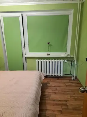 a bedroom with a bed and a window and a radiator at Nakvynė ir poilsis Zarasų mieste visai šeimai in Zarasai