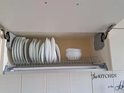 a shelf in a kitchen with plates and bowls at Nakvynė ir poilsis Zarasų mieste visai šeimai in Zarasai