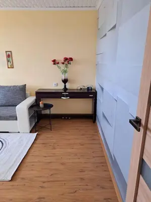 a room with a table with a vase of flowers on it at Nakvynė ir poilsis Zarasų mieste visai šeimai in Zarasai