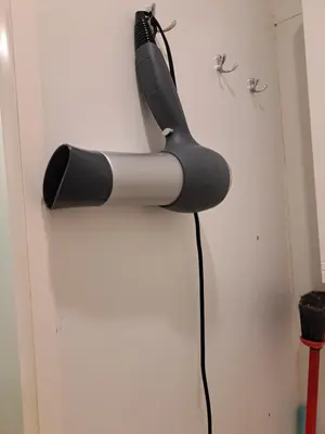 a black and grey blow dryer hanging on a door at Nakvynė ir poilsis Zarasų mieste visai šeimai in Zarasai
