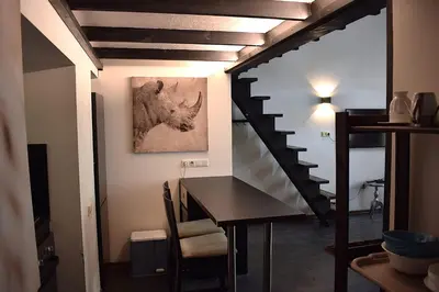 a dining room with a table and a staircase at BOSTONA Flat in Vilnius