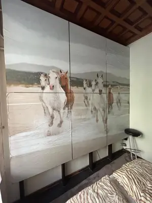 a painting of cows on a wall in a bedroom at BOSTONA Flat in Vilnius