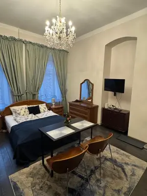 a bedroom with a bed and a table and chairs at BOSTONA Flat in Vilnius