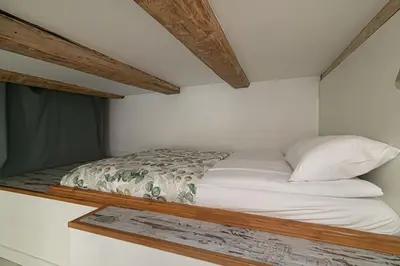 a bed in a white room with avertisementatronatronstrationstrationstrationstrationstration at Lovely Loft in Old Town with free parking by URBAN RENT in Vilnius