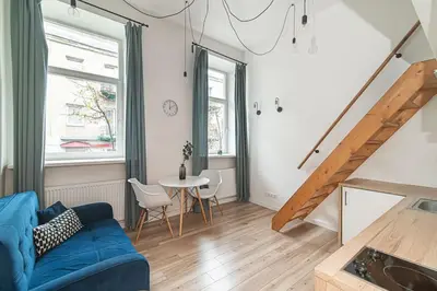 a living room with a blue couch and a table at Lovely Loft in Old Town with free parking by URBAN RENT in Vilnius