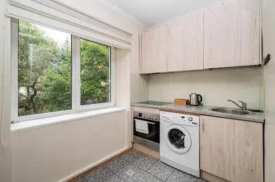 a kitchen with a washing machine and a window at Central and Comfy 2 Bedroom Apartment by Reside Baltic in Vilnius