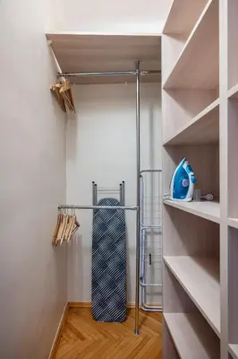 a walk in closet with white walls and wood floors at Central and Comfy 2 Bedroom Apartment by Reside Baltic in Vilnius