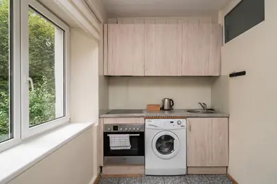 a small kitchen with a washing machine and a window at Central and Comfy 2 Bedroom Apartment by Reside Baltic in Vilnius