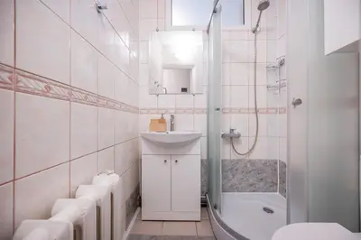 a white bathroom with a sink and a shower at Central and Comfy 2 Bedroom Apartment by Reside Baltic in Vilnius