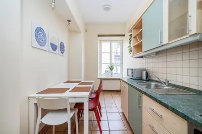 a kitchen with a table and chairs and a sink at Central and Lovely Apartment in Vilnius Old Town by Reside Baltic in Vilnius