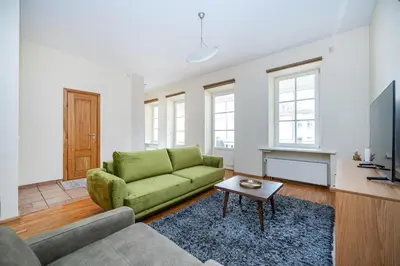 a living room with a green couch and a tv at Central and Lovely Apartment in Vilnius Old Town by Reside Baltic in Vilnius