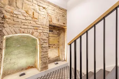 a room with a stone wall and a staircase at Classic Apartments In The Prestigious Stikliu Str by Reside Baltic in Vilnius