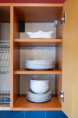 a cupboard with plates and dishes in it at Classic Apartments In The Prestigious Stikliu Str by Reside Baltic in Vilnius