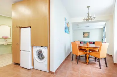 a kitchen and dining room with a table and a washing machine at Classic Apartments In The Prestigious Stikliu Str by Reside Baltic in Vilnius