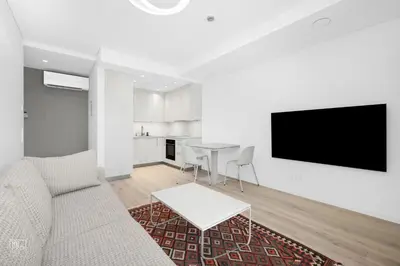 a living room with a couch and a tv on a wall at Bright 2BR with Private EV Parking, workspace, AC in Kaunas