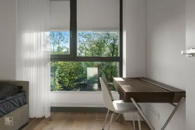 a desk and chairs in a room with a window at Bright 2BR with Private EV Parking, workspace, AC in Kaunas