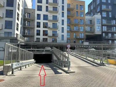 a tunnel with a red arrow in front of some buildings at Bright 2BR with Private EV Parking, workspace, AC in Kaunas
