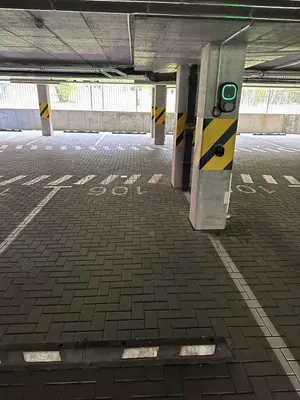an empty parking garage with a sign on the floor at Bright 2BR with Private EV Parking, workspace, AC in Kaunas