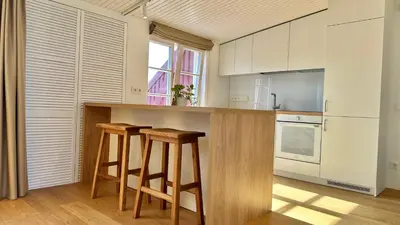 a kitchen with wooden stools and a counter top at City Center Appartment in Vilnius