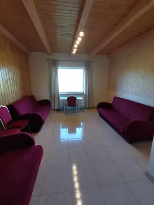 a living room with purple couches and a window at Poilsio namai Aerodromas in Bajorai