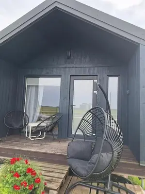 a black house with two chairs on a deck at MiNi homes in Piniava