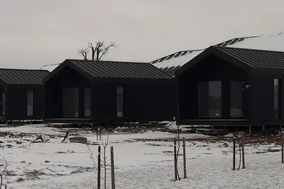 a row of black houses in the snow at MiNi homes in Piniava