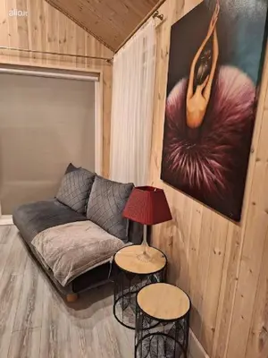 a living room with a couch and a table with a lamp at MiNi homes in Piniava