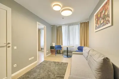 a living room with a couch and a table at Asian Magnolia Express Studio Apartments in Druskininkai