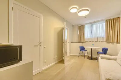 a living room with a couch and a table at Asian Magnolia Express Studio Apartments in Druskininkai